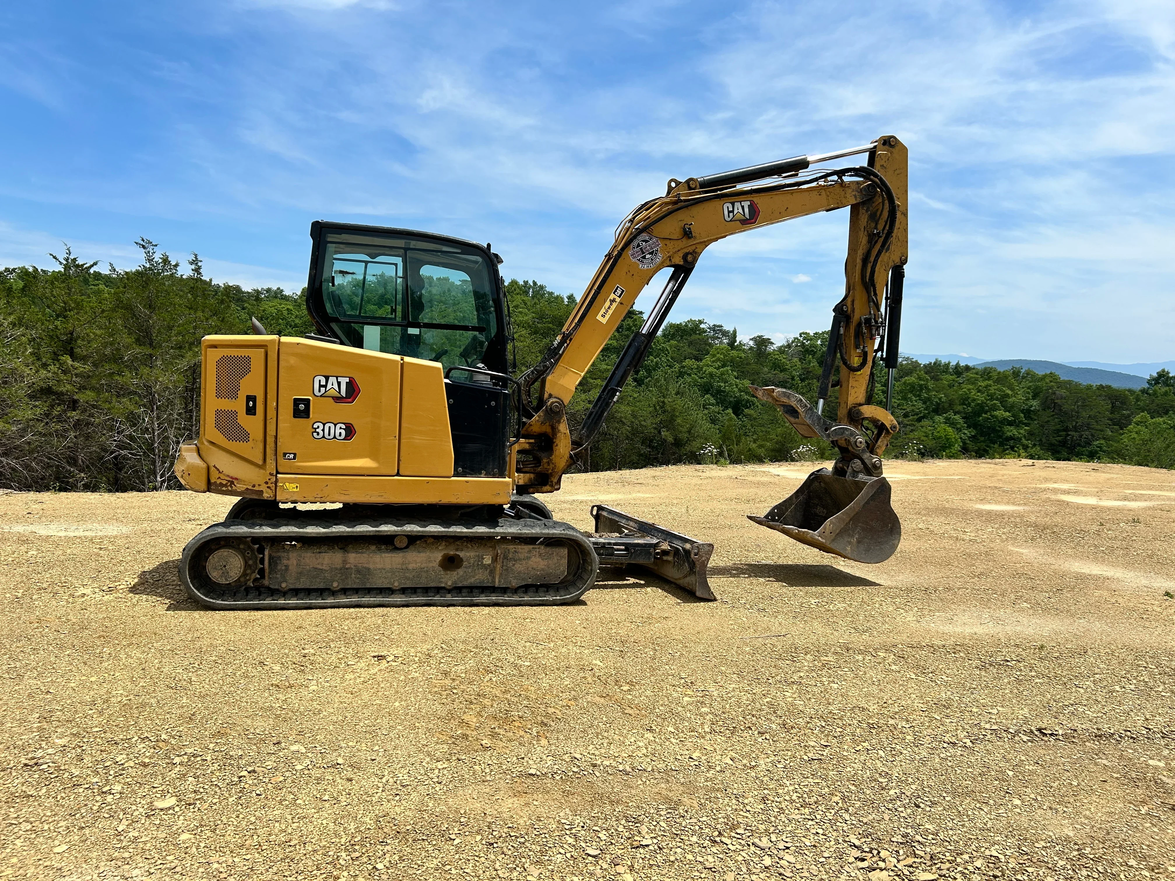 Cat 306 compact excavator with bucket attachment on graded dirt site